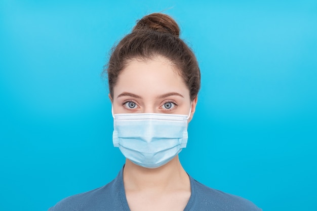 Giovane ragazza con grandi occhi azzurri in una mascherina medica