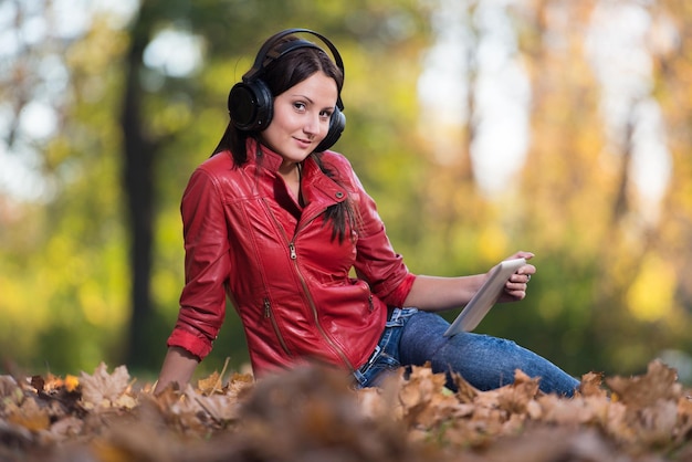 Giovane Ragazza Con Le Cuffie Godendo Della Musica In Autunno