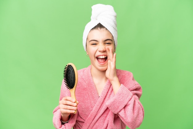 Giovane ragazza con pettine per capelli che grida con la bocca spalancata