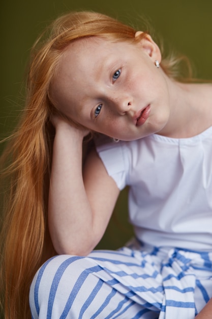 Giovane ragazza dai capelli rossi con bei capelli lunghi e grandi occhi blu