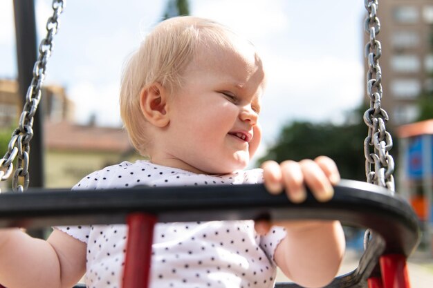 Giovane ragazza del bambino che si siede al sicuro in un parco