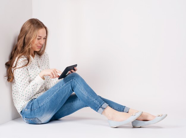 Giovane ragazza dello studente di bellezza con tablet