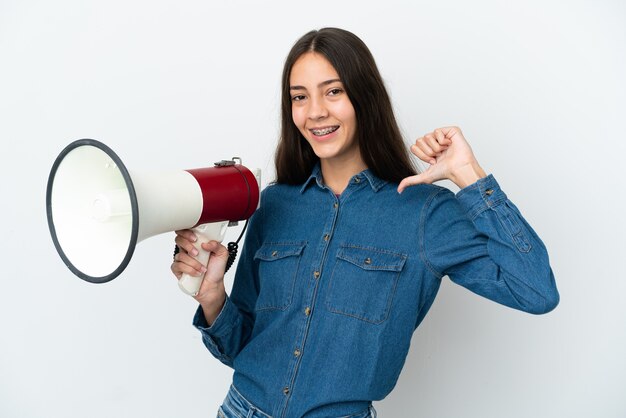 Giovane ragazza francese isolata su priorità bassa bianca che tiene un megafono e orgoglioso e soddisfatto di sé