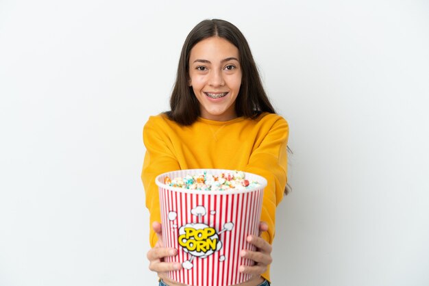 Giovane ragazza francese isolata su sfondo bianco con in mano un grande secchio di popcorn