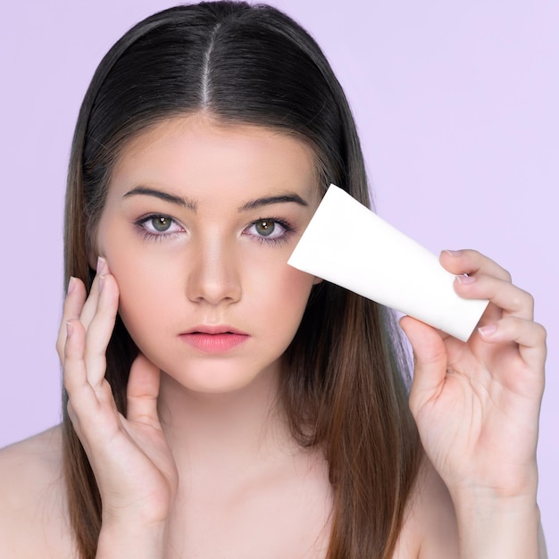 Giovane ragazza grassottella affascinante con il tubolo della lozione della tenuta naturale di bellezza