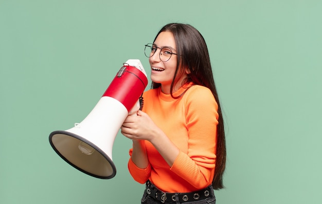 Giovane ragazza graziosa dell'adolescente. espressione felice e sorpresa. concetto di megafono