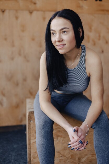 Giovane ragazza in abbigliamento sportivo in una palestra, un tema di fitness, un crossfit e sport