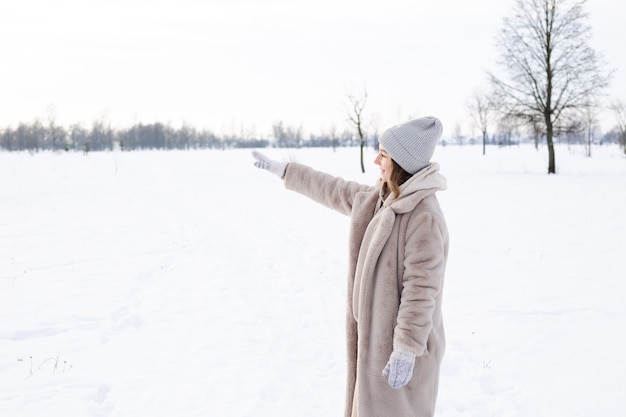 Giovane ragazza in abiti beige pelliccia fatta di pelliccia artificiale passeggiate in inverno