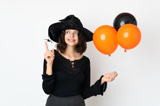 Giovane ragazza in costume di Halloween sul muro bianco