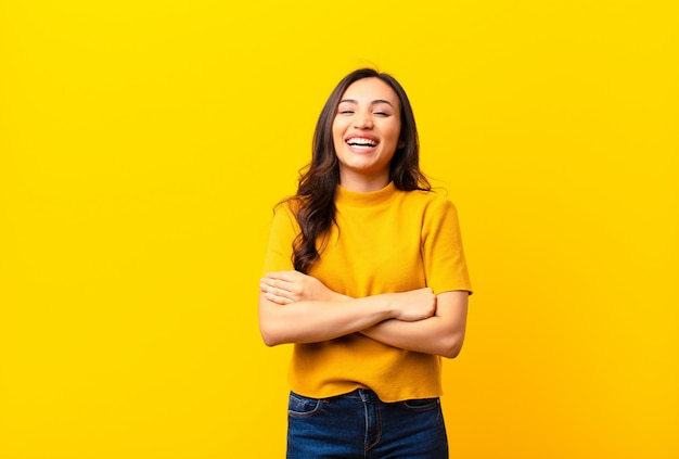 giovane ragazza in maglietta colorata sorridente con le braccia incrociate