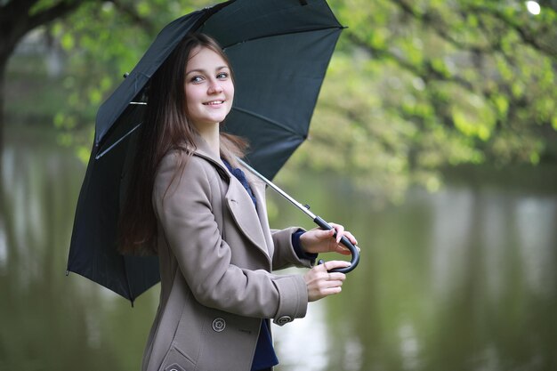 Giovane ragazza in un cappotto in un parco primaverile