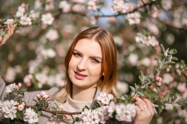 Giovane ragazza in un frutteto di mele in fiore