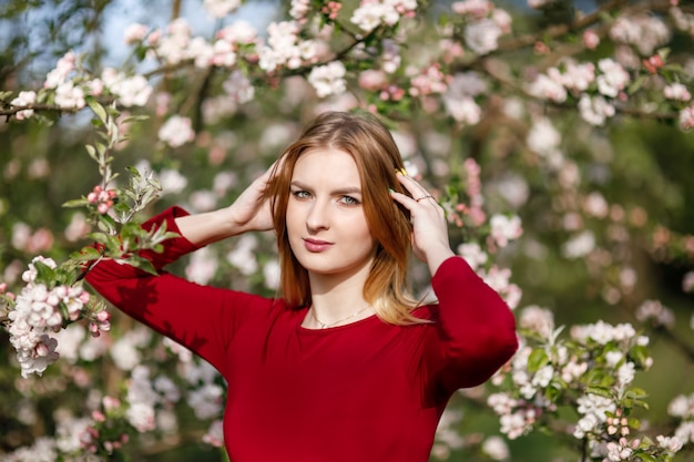 Giovane ragazza in un frutteto di mele in fiore