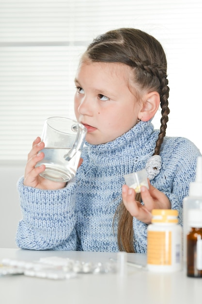 Giovane ragazza malata che prende le medicine