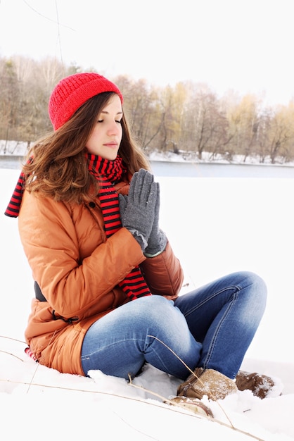 Giovane ragazza nella posa del loto nella neve