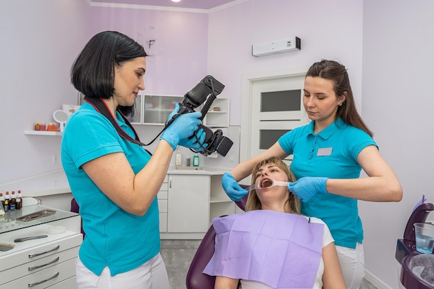 Giovane ragazza paziente che scatta foto dei denti in odontoiatria per confrontare il processo di trattamento