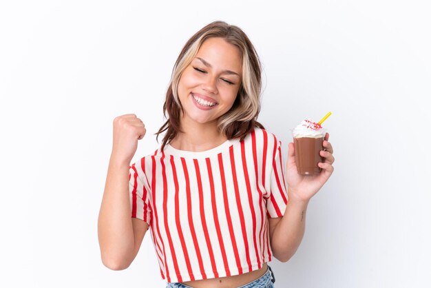 Giovane ragazza russa con cappuccino isolato su sfondo bianco che celebra una vittoria