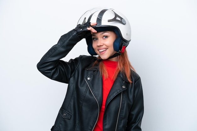 Giovane ragazza russa con un casco da motociclista isolato su sfondo bianco che fa un gesto a sorpresa mentre guarda di lato