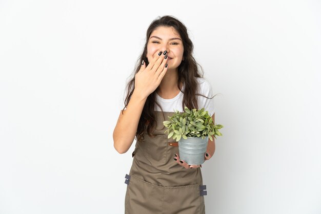 Giovane ragazza russa del giardiniere che tiene una pianta isolata