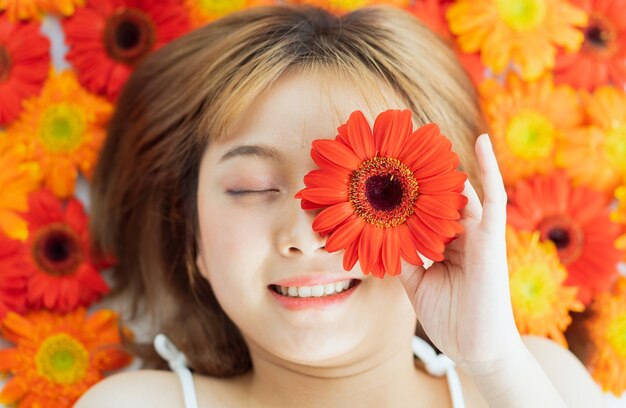 Giovane ragazza sdraiata sul fiore con un'espressione felice happy