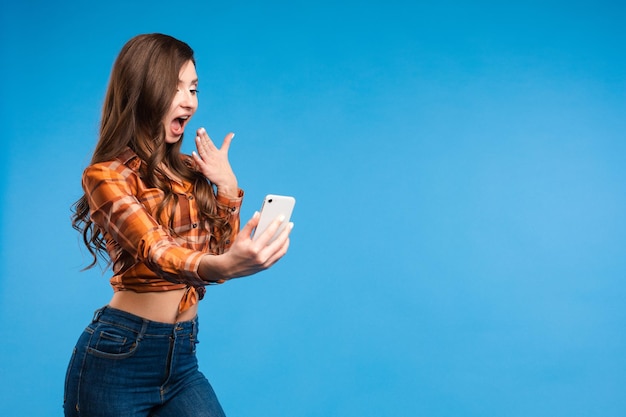 Giovane ragazza seducente che fa foto È in piedi e si fa selfie con lo smartphone