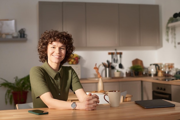 Giovane ragazza seduta in cucina domestica