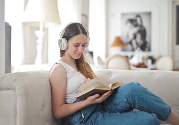 giovane ragazza su un divano legge un libro