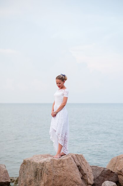 Giovane ragazza sulle rocce nel mare