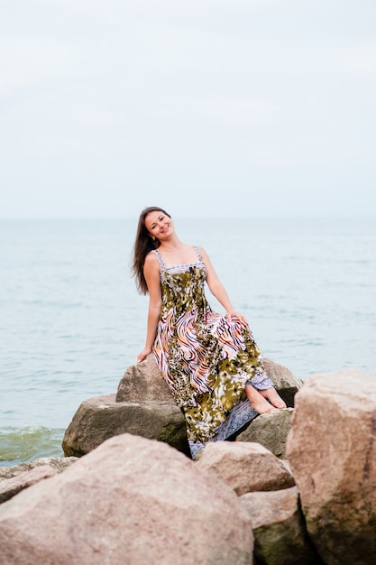 Giovane ragazza sulle rocce nel mare