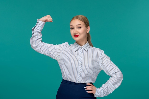 Giovane ragazza sveglia della signora di affari in vestito dell'ufficio che mostra il bicipite fuori