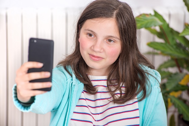 Giovane ragazza teenager che fa un selfie