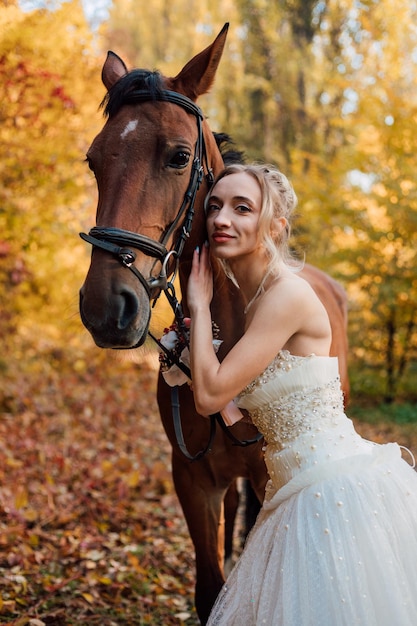 Giovane ragazza tenera della sposa che posa vicino nella foresta di autunno