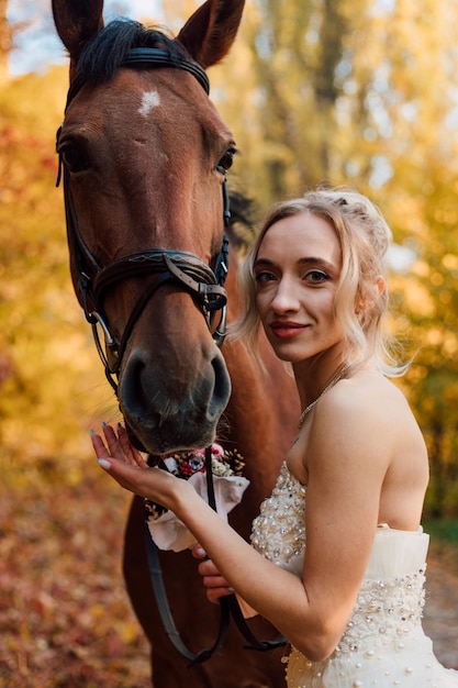 Giovane ragazza tenera della sposa che posa vicino nella foresta di autunno