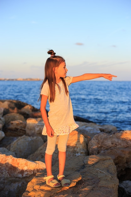 Giovane ragazza vicino all'oceano in una giornata estiva