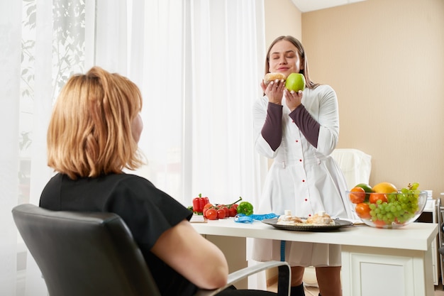 Giovane ragazza visitando il nutrizionista per perdere peso con l'aiuto del programma di dieta.