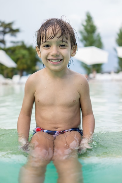 Giovane ragazzo bambino bambino spruzzi in piscina divertirsi attività per il tempo libero