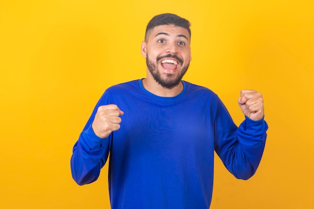 Giovane ragazzo bello che celebra la vittoria eccitato