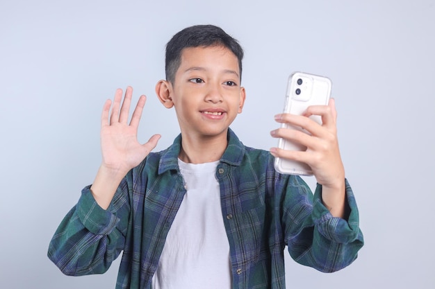 Giovane ragazzo bello che saluta lo smartphone che registra video Vlog o che fa una videochiama