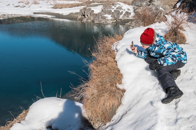 Giovane ragazzo che cattura le foto sul fiume della costa