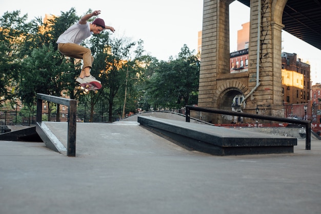 Giovane ragazzo che esegue trucchi con lo skateboard in uno skate park