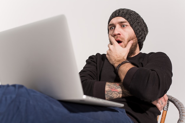 Giovane ragazzo con la barba con un computer portatile