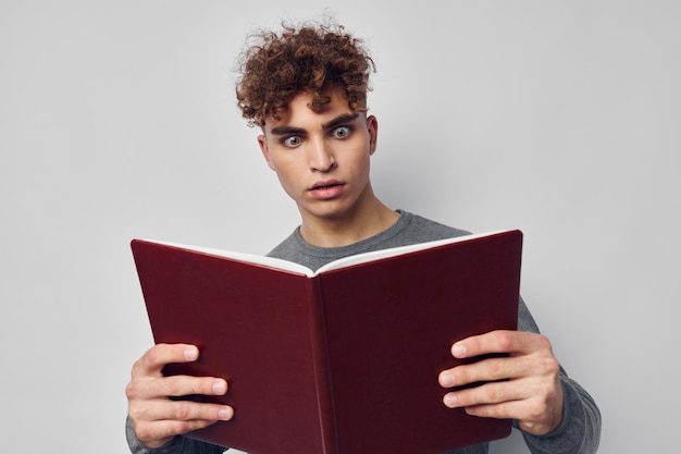 Giovane ragazzo con la posa di istruzione di apprendimento del libro