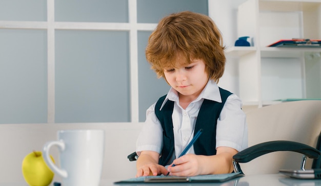 Giovane ragazzo d'affari Ritratto di un bambino d'affari in ufficio moderno Seriamente bambini piccoli uomo d'affari seduto in ufficio