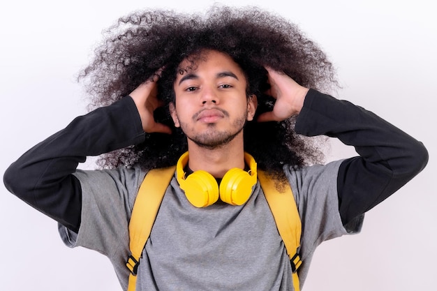 Giovane ragazzo del college con i capelli afro su sfondo bianco ritratto sorridente vedendo fotocamera