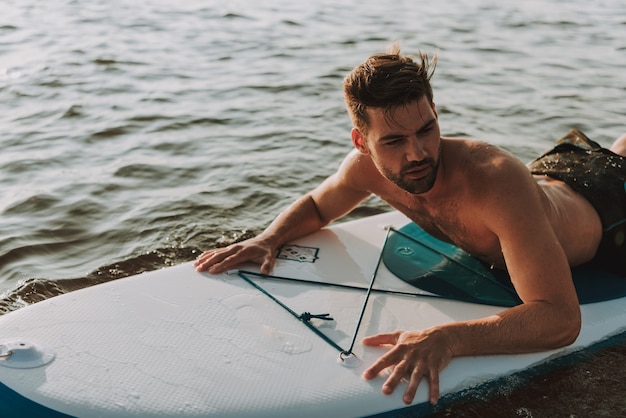 Giovane Ragazzo è Pone In Surf In Acqua E Nuota.