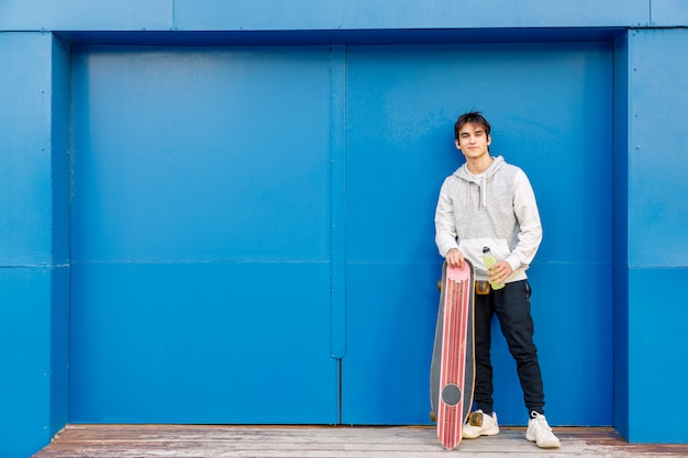 giovane ragazzo in piedi con uno skateboard