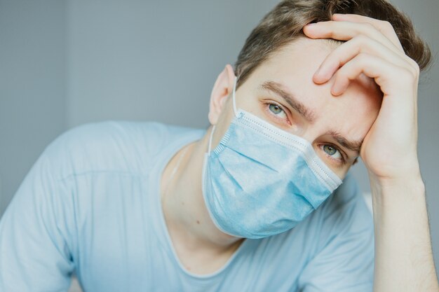 Giovane ragazzo in una maschera medica a casa