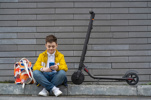 Giovane ragazzo moderno che chiacchiera sullo smartphone