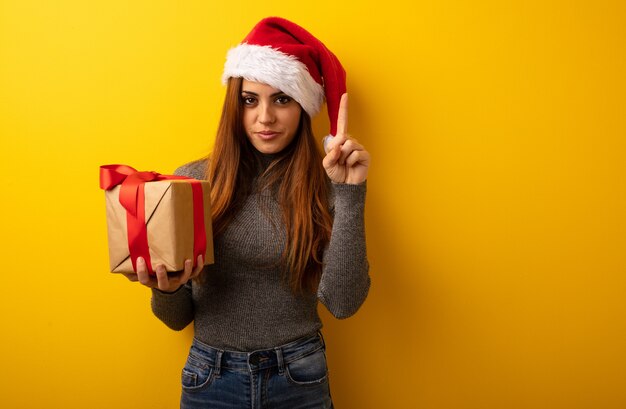 Giovane regalo grazioso della holding della donna che mostra numero uno