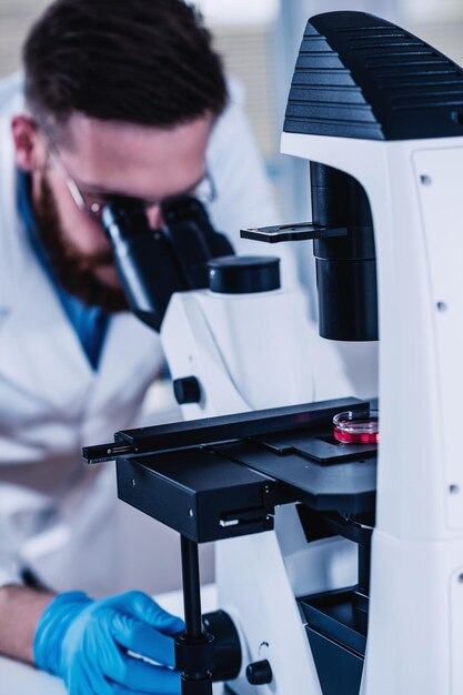 Giovane Ricercatore Maschio Guardando I Campioni Al Microscopio